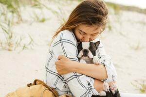 uma mulher é sentado em a de praia com dela cachorro foto