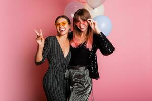 dois mulheres , melhor amigos a comemorar galinha festa, posando com nupcial foto adereços em Rosa fundo.