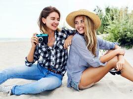 dois feliz fêmea amigos, entusiasmado modelo com dela pessoal fotógrafo . foto