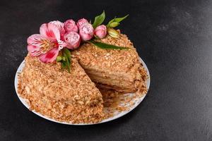 Bolo fresco delicioso napoleão com creme em um fundo escuro foto