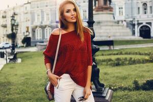 rua retrato do uma jovem lindo elegante mulher dentro vermelho suéter . foto