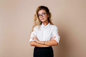 atraente bem sucedido o negócio mulher com sincero sorrir olhando às Câmera. professor ou empregado. bege fundo. foto