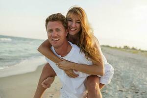 romântico momentos do feliz europeu casal dentro amor desfrutando tropical período de férias em a de praia. abraçando e tendo Diversão junto. olhando às Câmera. foto