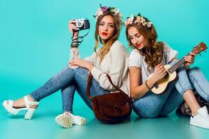 estúdio estilo de vida retrato do dois bonita jovem Loiras feliz meninas tendo Diversão. foto