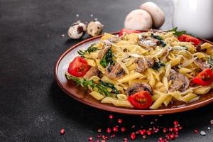 macarrão com cogumelos, queijo, espinafre, rukkola e tomate cereja foto