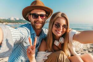 jovem atraente sorridente feliz homem e mulher dentro oculos de sol deitado em areia de praia foto