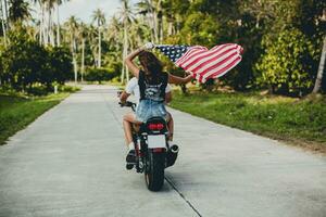 jovem casal dentro amor, equitação uma motocicleta, abraço, paixão, livre espírito, americano bandeira foto