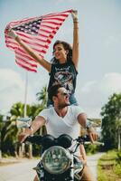 jovem casal dentro amor, equitação uma motocicleta, abraço, paixão, livre espírito, americano bandeira foto