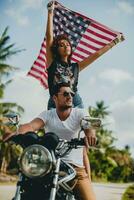 jovem casal dentro amor, equitação uma motocicleta, abraço, paixão, livre espírito, americano bandeira foto