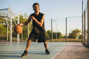 Preto homem fazendo Esportes, jogando basquetebol em nascer do sol, ativo estilo de vida, ensolarado verão manhã foto