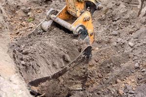 a escavadeira moderna realiza trabalhos de escavação no canteiro de obras