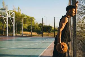 Preto homem fazendo Esportes, jogando basquetebol em nascer do sol, ativo estilo de vida, ensolarado verão manhã foto