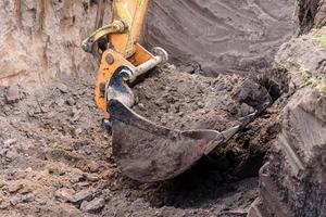 a escavadeira moderna realiza trabalhos de escavação no canteiro de obras foto