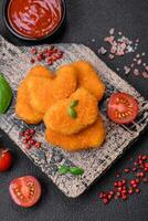 deliciosos nuggets de frango crocantes frescos em um fundo escuro de concreto foto