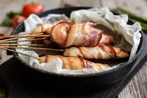 rolo com bacon e frango picado em um guisado com aspargos frescos foto