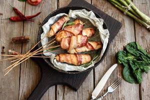 rolo com bacon e frango picado em um guisado com aspargos frescos foto
