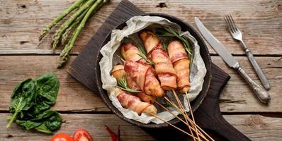 rolo com bacon e frango picado em um guisado com aspargos frescos foto