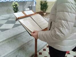 mulher Rezar em a piedosos Bíblia. segurando mãos dentro oração em uma de madeira mesa. oração para Deus para a crise do cristão vida. oração em uma piedosos Bíblia dentro Igreja conceito para fé. foto