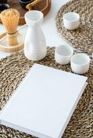 livro brincar Projeto. em branco branco livro em jantar mesa dentro ásia estilo com talheres foto