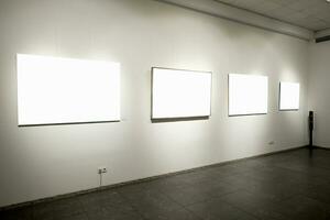 em branco cenário quadros em cinzento parede com brilhando lâmpada, zombar acima foto