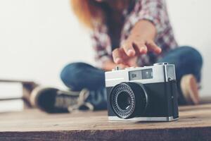 mão de mulher jovem hippie estender a mão para pegar a câmera retro. foto