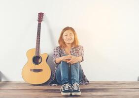 hipster mulher estilo retrato relaxando com guitarra parece tão feliz. foto