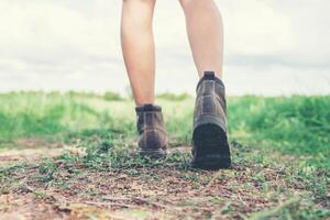 pés de mulher jovem aventura andando sobre cascalho na zona rural. foto