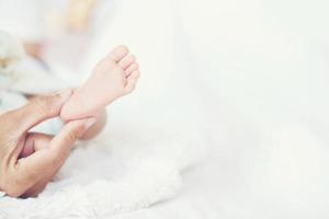 pés do bebê newbron nas mãos da mãe. foto