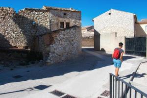 mulher com mochila caminhando por vila medieval foto