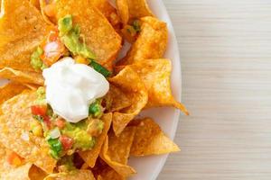 chips de tortilla de nachos mexicanos com jalapeño, guacamole, molho de tomate e molho foto