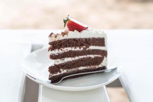 Bolo de baunilha e chocolate com morango no café foto