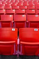 fila de cadeiras dobráveis vermelhas em um estádio.