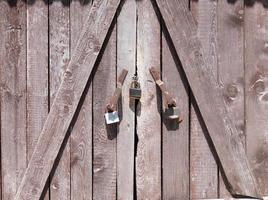 um portão de celeiro de madeira com cadeados fechados foto