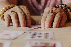 leitura de cartas de adivinhação, magia da avó, leitura da sorte, mãos de mulheres foto