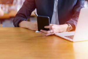 jovem usando um telefone inteligente em sua mesa foto