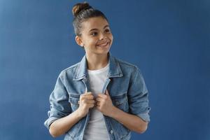 adolescente positiva com óculos desvia o olhar foto