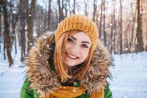 retrato de inverno de uma linda garota com um chapéu e luvas foto