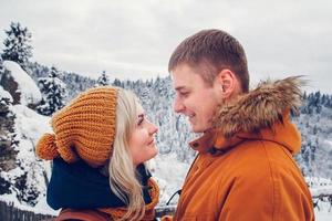 casal apaixonado se abraçando ao ar livre em uma paisagem de neve foto