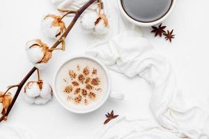 cappuccino de café com estrelas de canela e anis em fundo branco foto