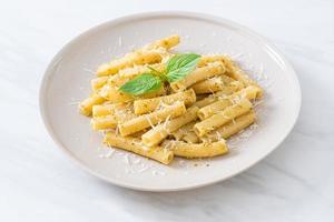 macarrão pesto rigatoni com queijo parmesão - comida italiana e comida vegetariana foto