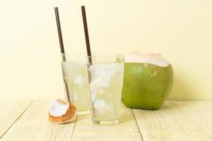 água de coco ou suco de coco em copo com cubo de gelo foto