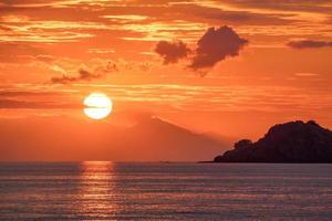 belo pôr do sol laranja dourado sobre o oceano. foto