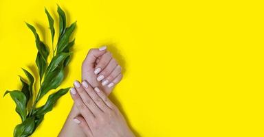manicure feminina em um fundo brilhante. amarelo foto