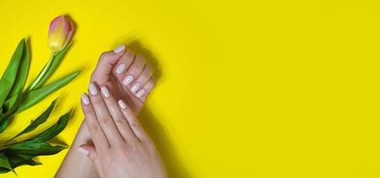 manicure feminina em um fundo brilhante. amarelo foto