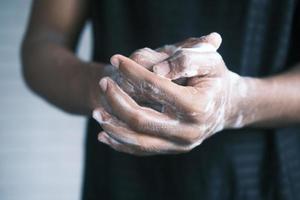 jovem lavando as mãos com sabão água morna foto