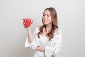 retrato linda mulher asiática segurando uma xícara de café ou caneca no fundo branco