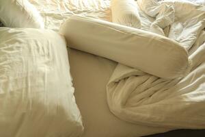 bagunçado hotel cama. branco travesseiro. branco rolar. branco cobertor. foto