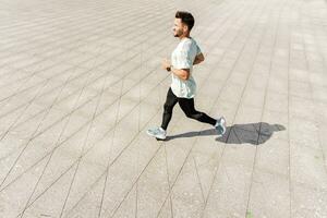 uma homem Treinamento ginástica dentro uma confortável camiseta. uma treinador com óculos faz uma corrida exercício cada dia, uma saudável estilo de vida. uma desportivo pessoa usa uma ginástica Assistir e uma corrida aplicativo. foto