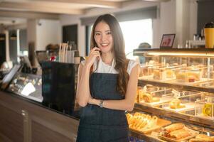 a ásia mulher empreendedor ou barista trabalhando dentro moderno café fazer compras , conceito pequeno o negócio foto