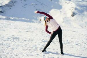 jovem mulher em pé e fazendo exercício em neve dentro Planalto foto